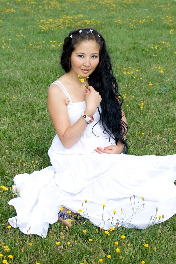 Beautiful pregnant girl sitting on grass