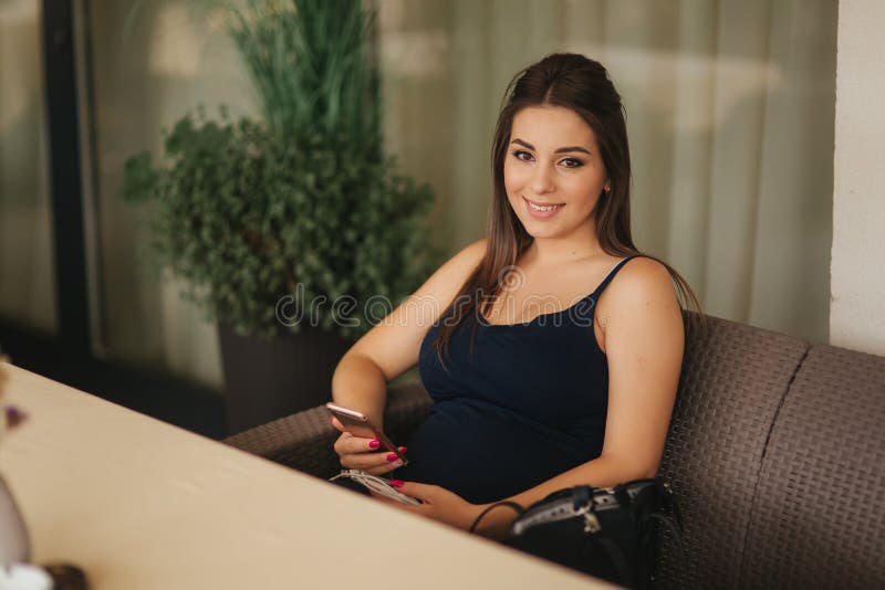 Beautiful pregnant lady in blue dress smile. Tenderness woman walk outside. Six months of pregnancy.