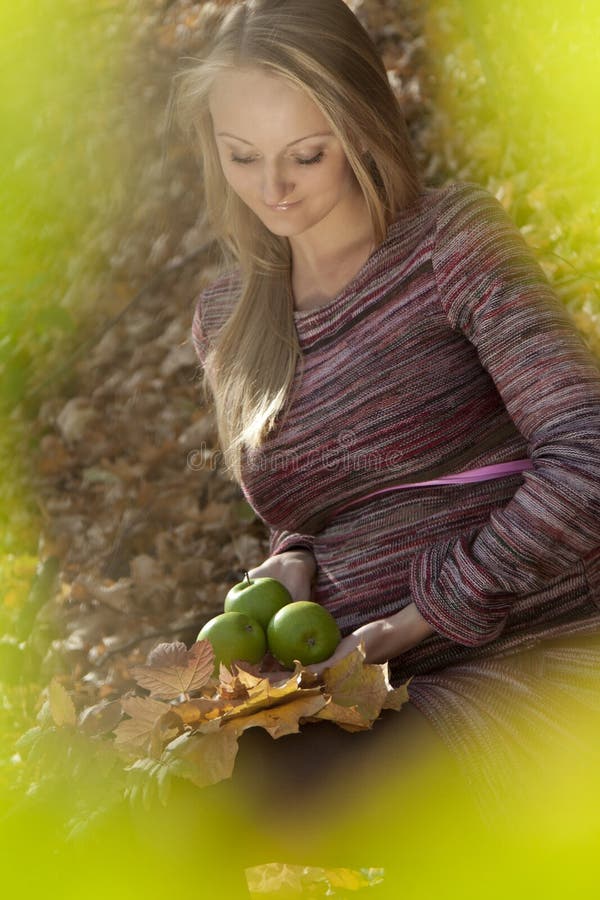 Beautiful pregnant woman with apple