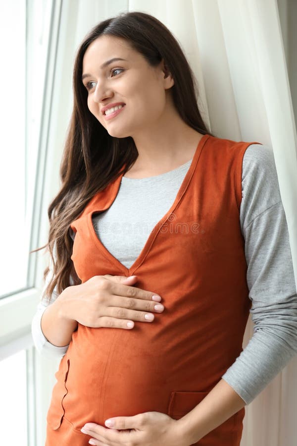 Beautiful pregnant woman near window stock image Beautiful pregnant woman near window stock image