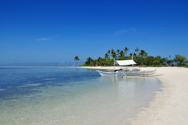 Boot angedockt an einem wunderschönen, unberührten tropischen Insel Strand.