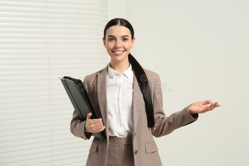Beautiful real estate agent with documents indoors stock photography