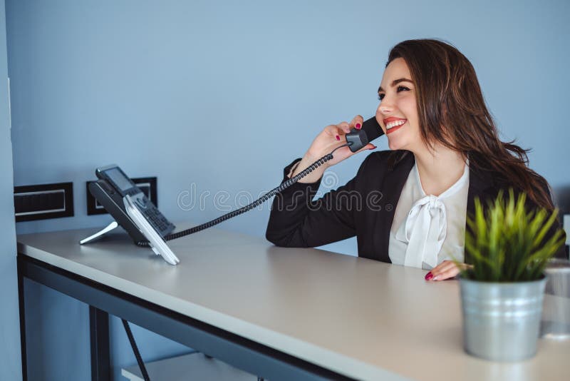 Receptionist girl talking on the phone and smiling stock images Receptionist girl talking on the phone and smiling stock images