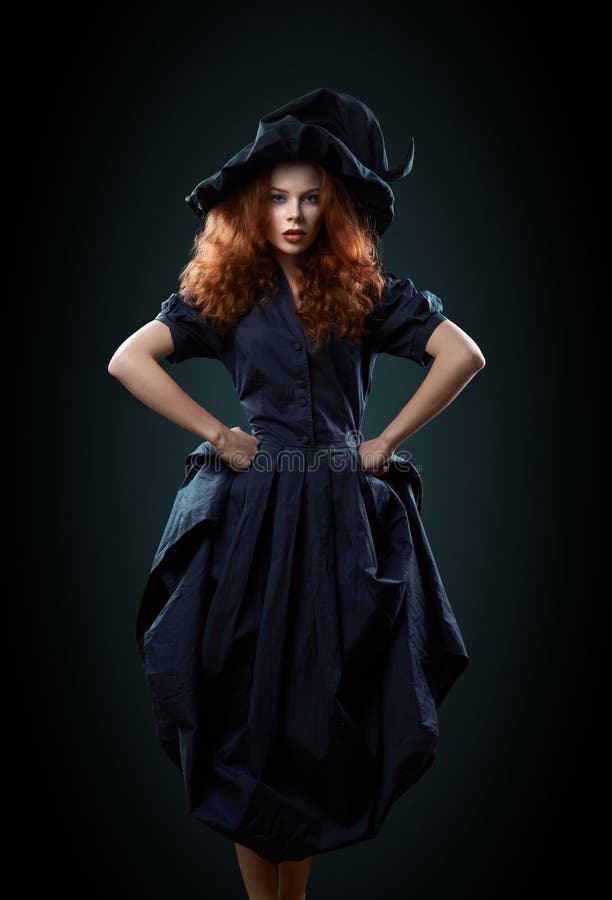 Beautiful red-haired girl in a costume witch