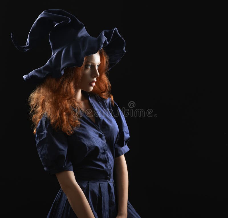 Beautiful red-haired girl in a costume witch