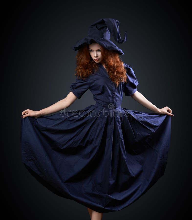 Beautiful red-haired girl in a costume witch