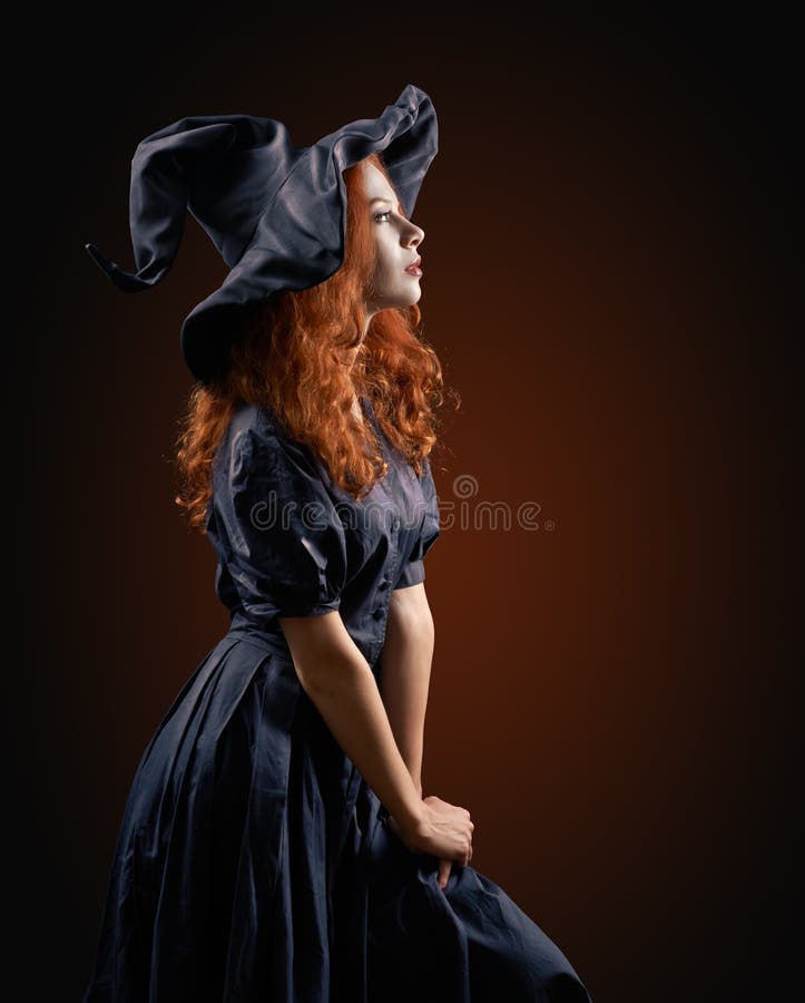 Beautiful red-haired girl in the witch costume