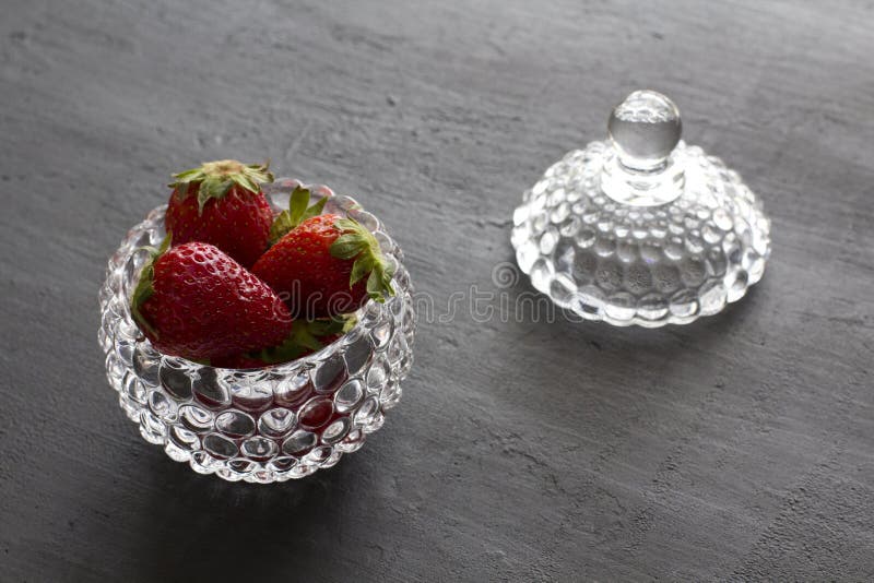 Beautiful red strawberry in glass round bowl. Strawberries on a black dark concrete background. Rustic style. Horizontal. royalty free stock photos Beautiful red strawberry in glass round bowl. Strawberries on a black dark concrete background. Rustic style. Horizontal. royalty free stock photos