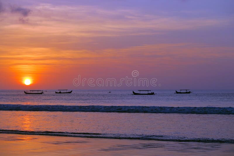 Beautiful red sun sunset with fisherman`s boats silhouettes, Kuta beach, Bali