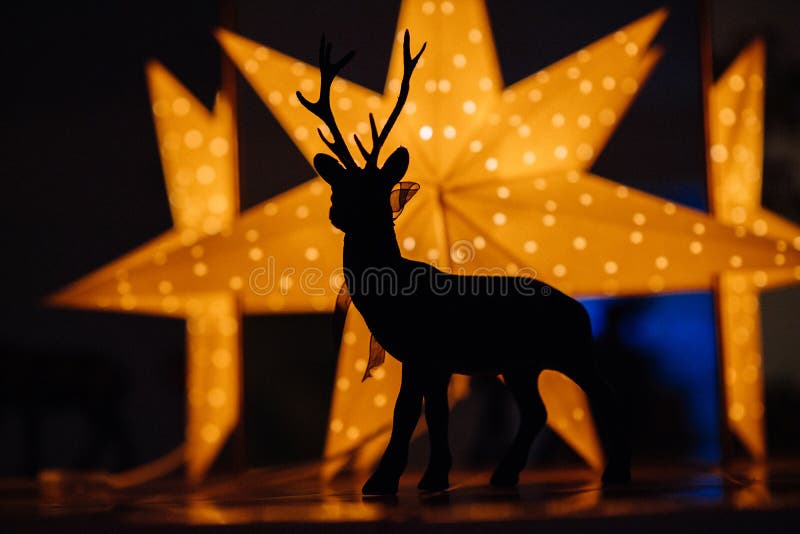 Beautiful reindeer silhouette with bright yellow holiday star in the background - defocused beautiful bokeh. Beautiful reindeer silhouette with bright yellow holiday star in the background - defocused beautiful bokeh