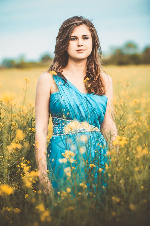 Beautiful romantic girl on blooming rapeseed field enjoying nature, young elegant woman walking, concept beauty and fashion, style royalty free stock images Beautiful romantic girl on blooming rapeseed field enjoying nature, young elegant woman walking, concept beauty and fashion, style royalty free stock images