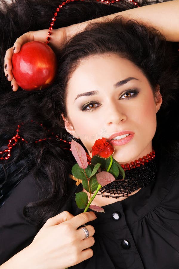 Beautiful romantic woman with a red apple and rose