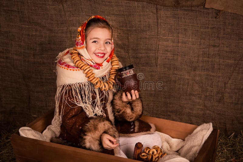 Beautiful russian girl in a shawl sitting in a cart