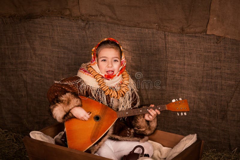 Beautiful russian girl in a shawl sitting in a cart