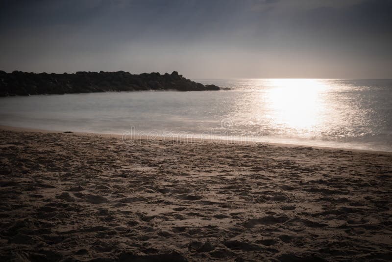Beautiful sandy scenic beach in sunset, with rocky breakwater in long exposure in basque country, france, creative background stock photography Beautiful sandy scenic beach in sunset, with rocky breakwater in long exposure in basque country, france, creative background stock photography
