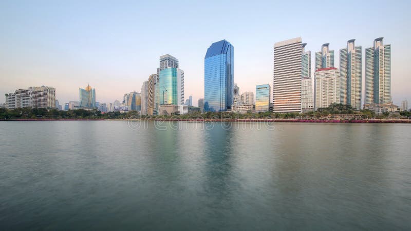 Beautiful scenery of lakeside skyscrapers reflecting on smooth lake water in Benjakiti Park, Bangkok Thailand. ~ View of glass curtain walled buildings and royalty free stock photos Beautiful scenery of lakeside skyscrapers reflecting on smooth lake water in Benjakiti Park, Bangkok Thailand. ~ View of glass curtain walled buildings and royalty free stock photos