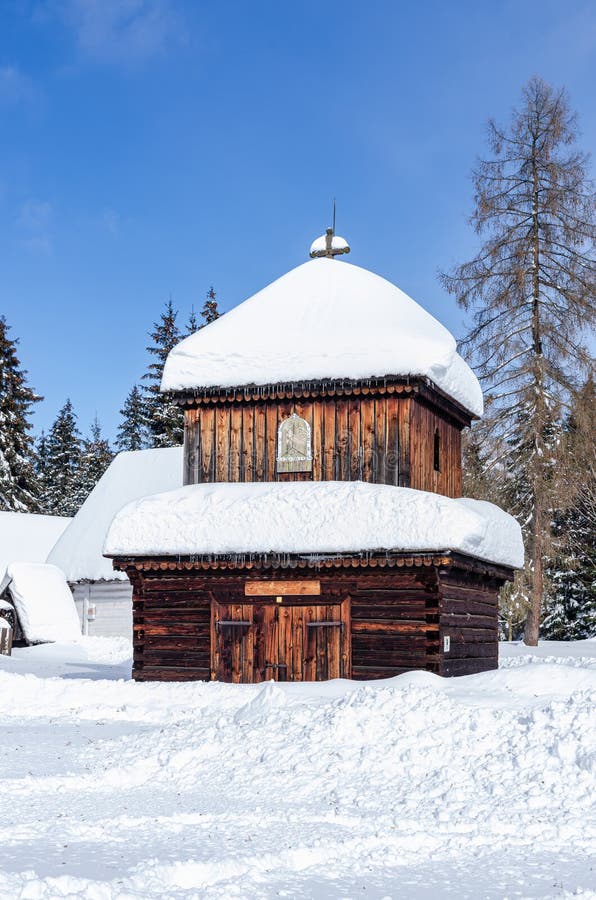Krásna scenéria so starou drevenou budovou pokrytou masívnym množstvom snehu.