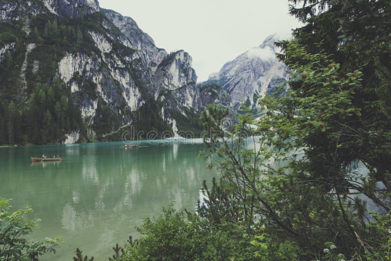 Beautiful scenery shot of the beautiful water surrounded by rocky mountains and green trees.