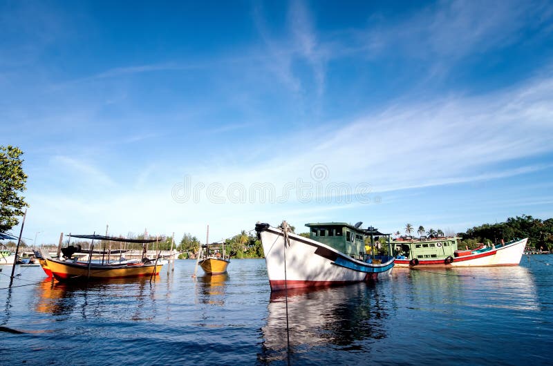 Traditional fisherman boat moored over beautiful sea view and sandy beach under bright sunny day