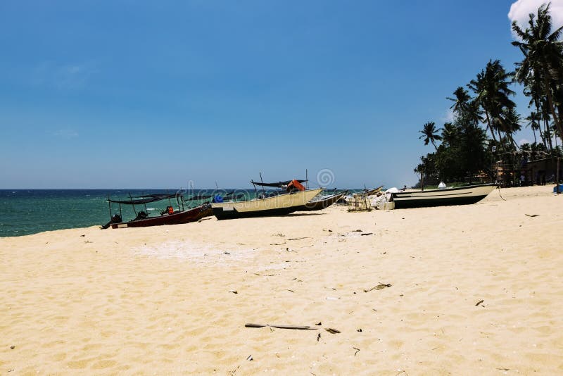 Traditional Fisherman Boat Stranded On Deserted Sandy Beach Under