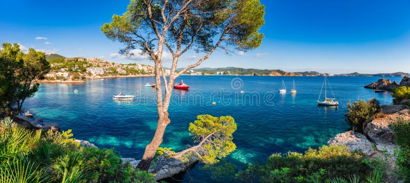 Idyllic island scenery, panorama view of bay with boats at Cala Fornells on Majorca, Spain Mediterranean Sea, Balearic Islands. Idyllic island scenery, panorama view of bay with boats at Cala Fornells on Majorca, Spain Mediterranean Sea, Balearic Islands.