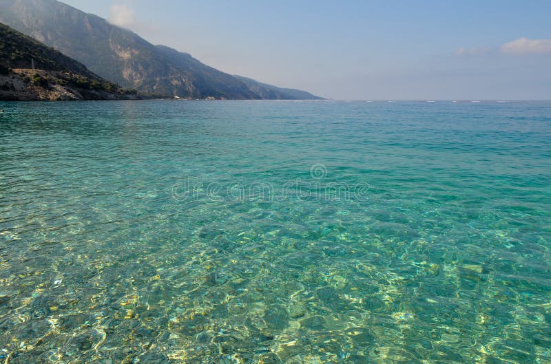 Beautiful seascape. Calm sea with clear water. With mountain and blue sky royalty free stock photo Beautiful seascape. Calm sea with clear water. With mountain and blue sky royalty free stock photo
