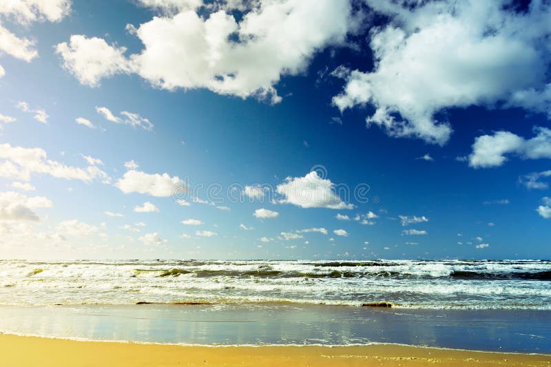 Beautiful seascape with sea waves, blue sky, white cumulus clouds and sand beach. Summer vacation tropical landscape. stock photos Beautiful seascape with sea waves, blue sky, white cumulus clouds and sand beach. Summer vacation tropical landscape. stock photos