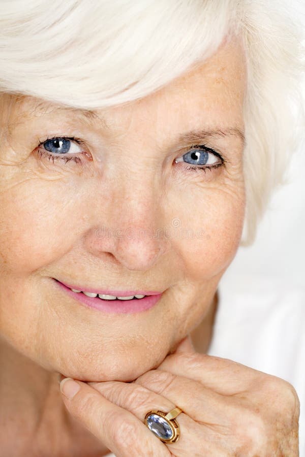 Portrét 75 rok stará dáma, closeup, rukou na brade, biele pozadie.