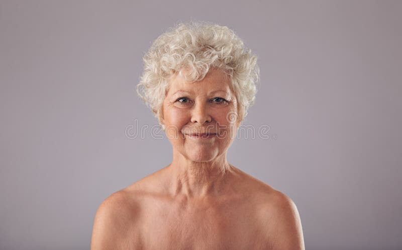 Beautiful Senior Woman Shirtless Against Grey Background