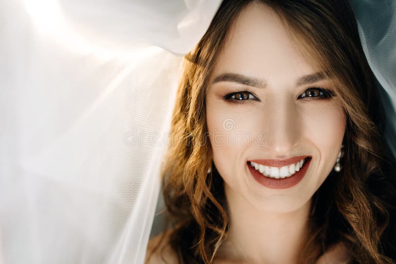 Beautiful bride in white dress posing under curtain stock image Beautiful bride in white dress posing under curtain stock image