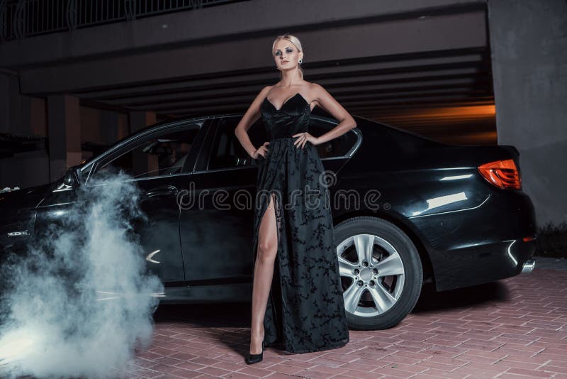 Beautiful woman posing standing near car