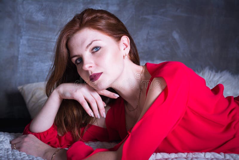 Beautiful and sexy woman with red hair and dressed in a red dress royalty free stock photos Beautiful and sexy woman with red hair and dressed in a red dress royalty free stock photos