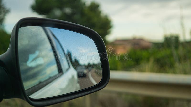 Beautiful shot of the dirty side mirror of a car on the road stock photography