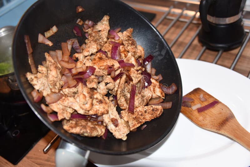 Beautiful Shot of Fried Chicken with Onion on a Frying Pan Stock Photo