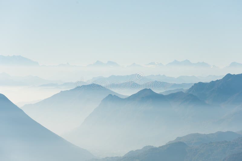 Beautiful shot of high white hilltops and mountains covered in fog.