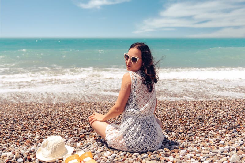 Beautiful sitting woman enjoying the idyllic scene of the sun, sea and beach. Beautyful beach in Antalya. royalty free stock images Beautiful sitting woman enjoying the idyllic scene of the sun, sea and beach. Beautyful beach in Antalya. royalty free stock images