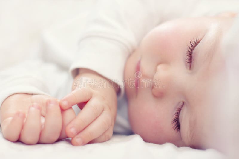 Beautiful sleeping newborn baby on white stock photography