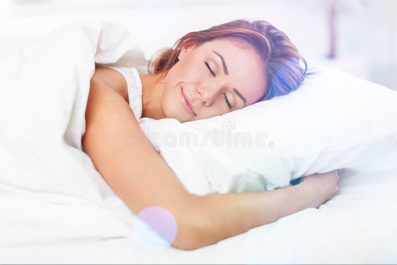 Beautiful sleeping woman in white bed with flares