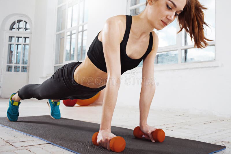 Beautiful slim brunette doing some push ups a the gym royalty free stock image Beautiful slim brunette doing some push ups a the gym royalty free stock image