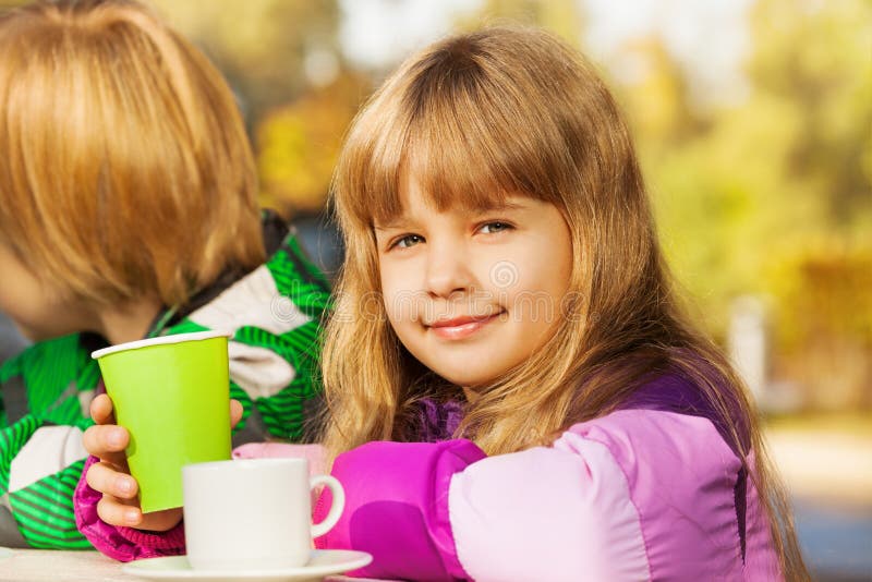 Beautiful small blond girl with green cup stock image Beautiful small blond girl with green cup stock image