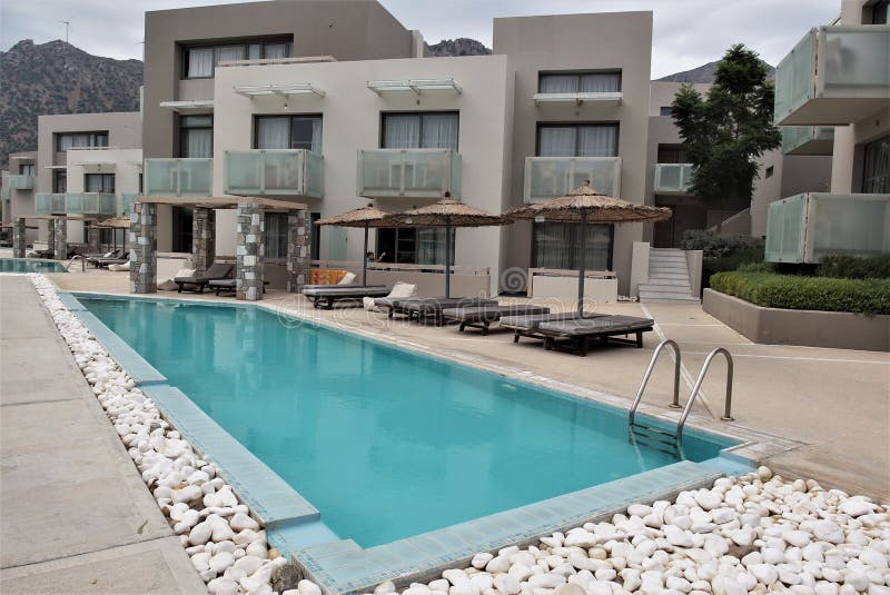 Beautiful small luxury hotel swimming pools with umbrellas and deck chairs in front of each apartments stock image Beautiful small luxury hotel swimming pools with umbrellas and deck chairs in front of each apartments stock image