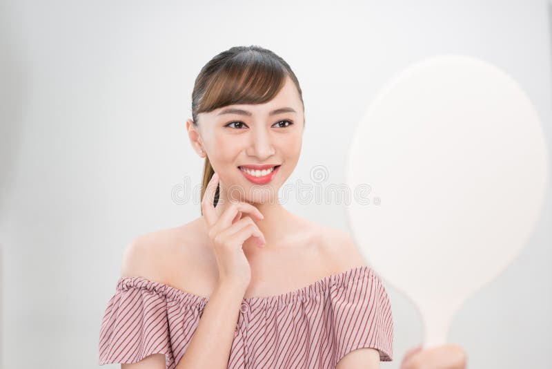 Beautiful smiling girl with natural makeup touching face