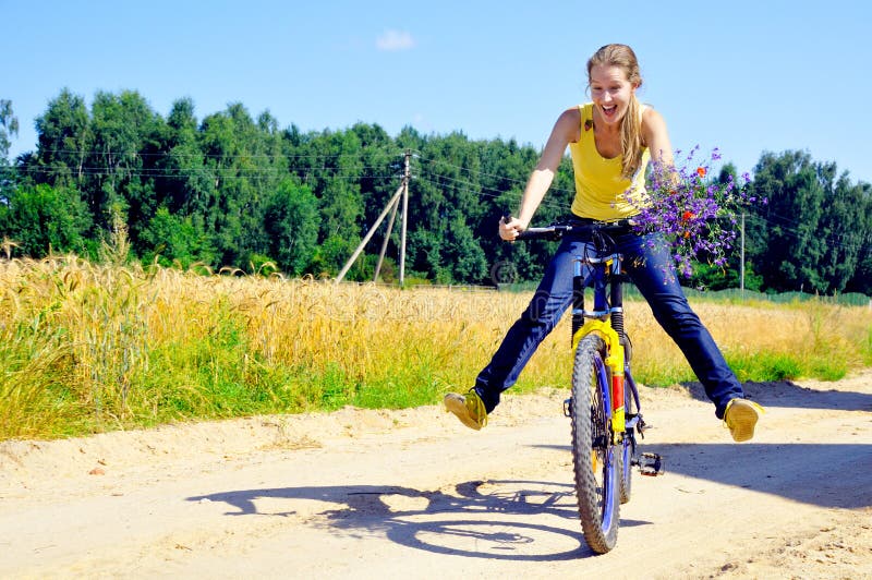 Beautiful smiling girl rides bicycle