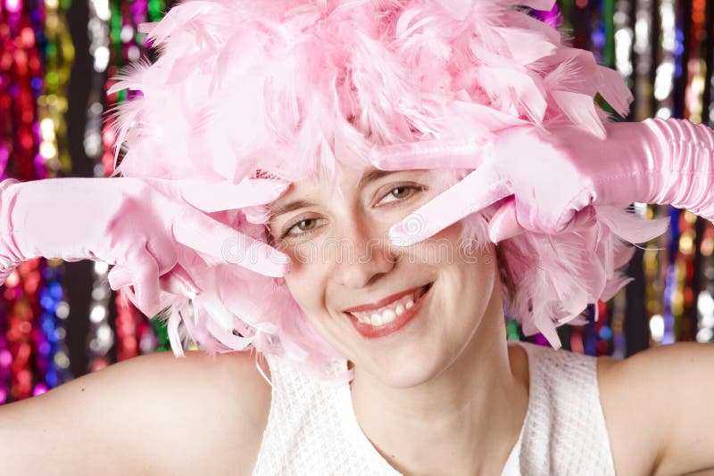 Beautiful smiling girl with wig from pink plumage