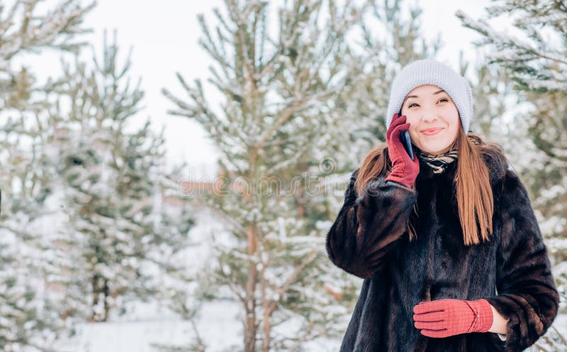 A woman using a smartphone in winter stock images A woman using a smartphone in winter stock images