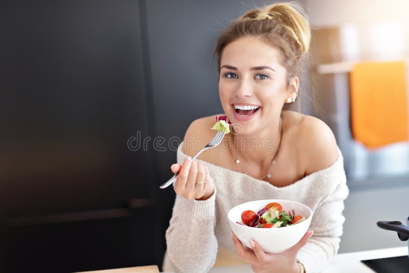 Beautiful Smiling Woman Eating Fresh Organic Vegetarian Salad In Modern Kitchen