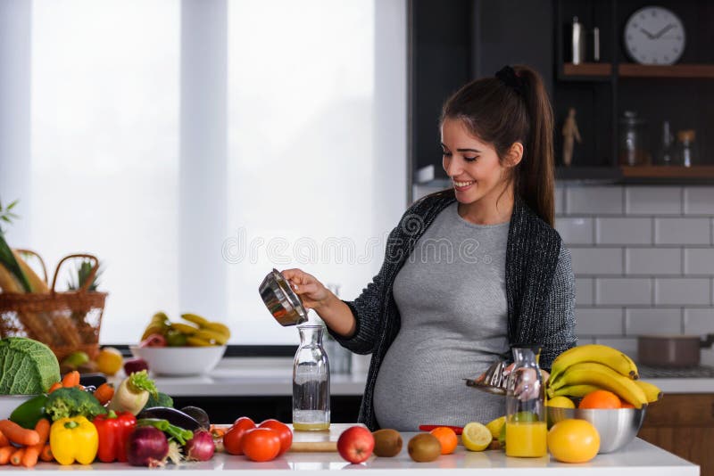 Young pregnant woman preparing healthy food with fruit and vegetables royalty free stock images Young pregnant woman preparing healthy food with fruit and vegetables royalty free stock images