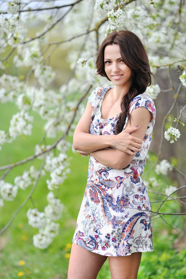 Beautiful Smiling Young Woman In A Park Standing With Hands Fold Stock