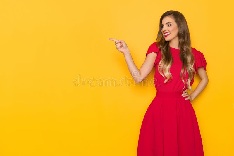 Beautiful Smiling Young Woman In Red Dress Is Pointing And Looking Away royalty free stock images Beautiful Smiling Young Woman In Red Dress Is Pointing And Looking Away royalty free stock images