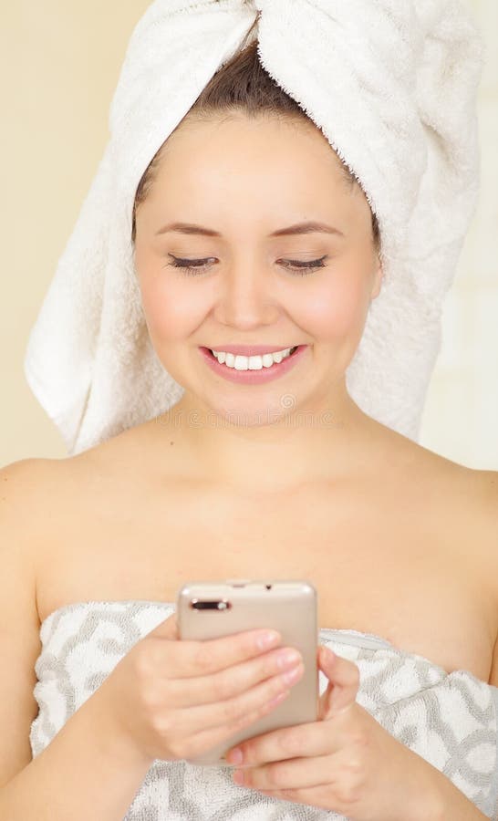 Beautiful Smiling Young Woman with a White Towel Covering Her Head is